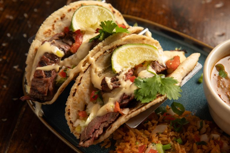 Close up of beef tacos on plate set on wooden table