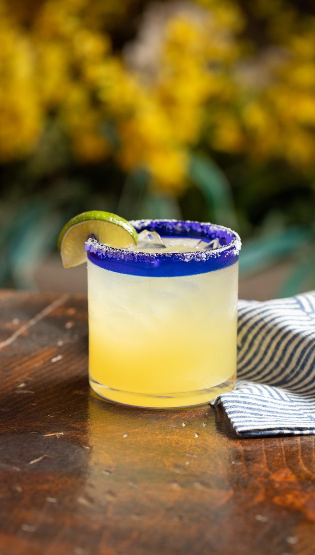 Classic margarita on table with yellow flowers in the background