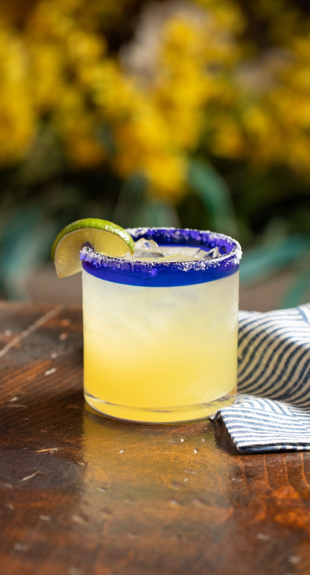 Classic margarita on table with yellow flowers in the background