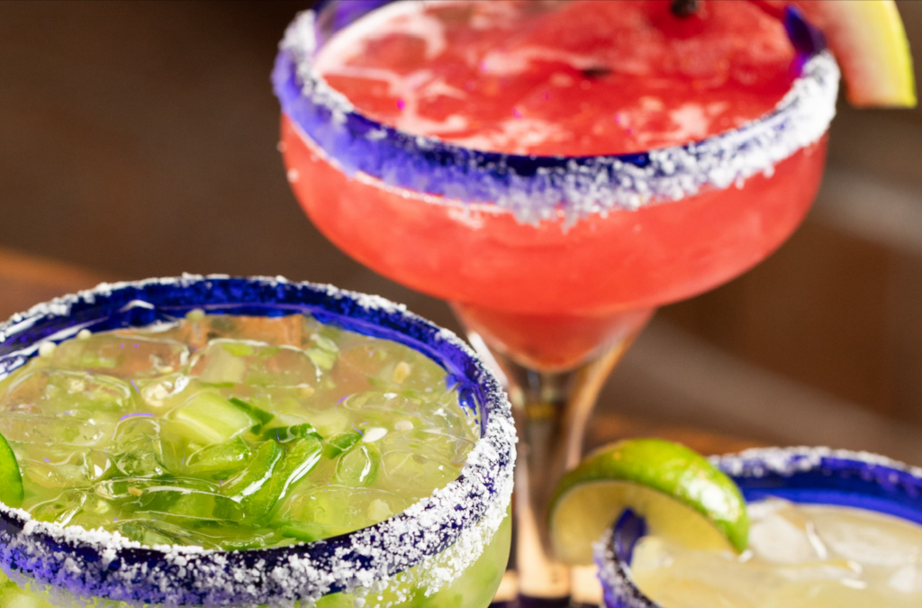 Close up of jalapeno margarita and watermelon margarita with salted rim