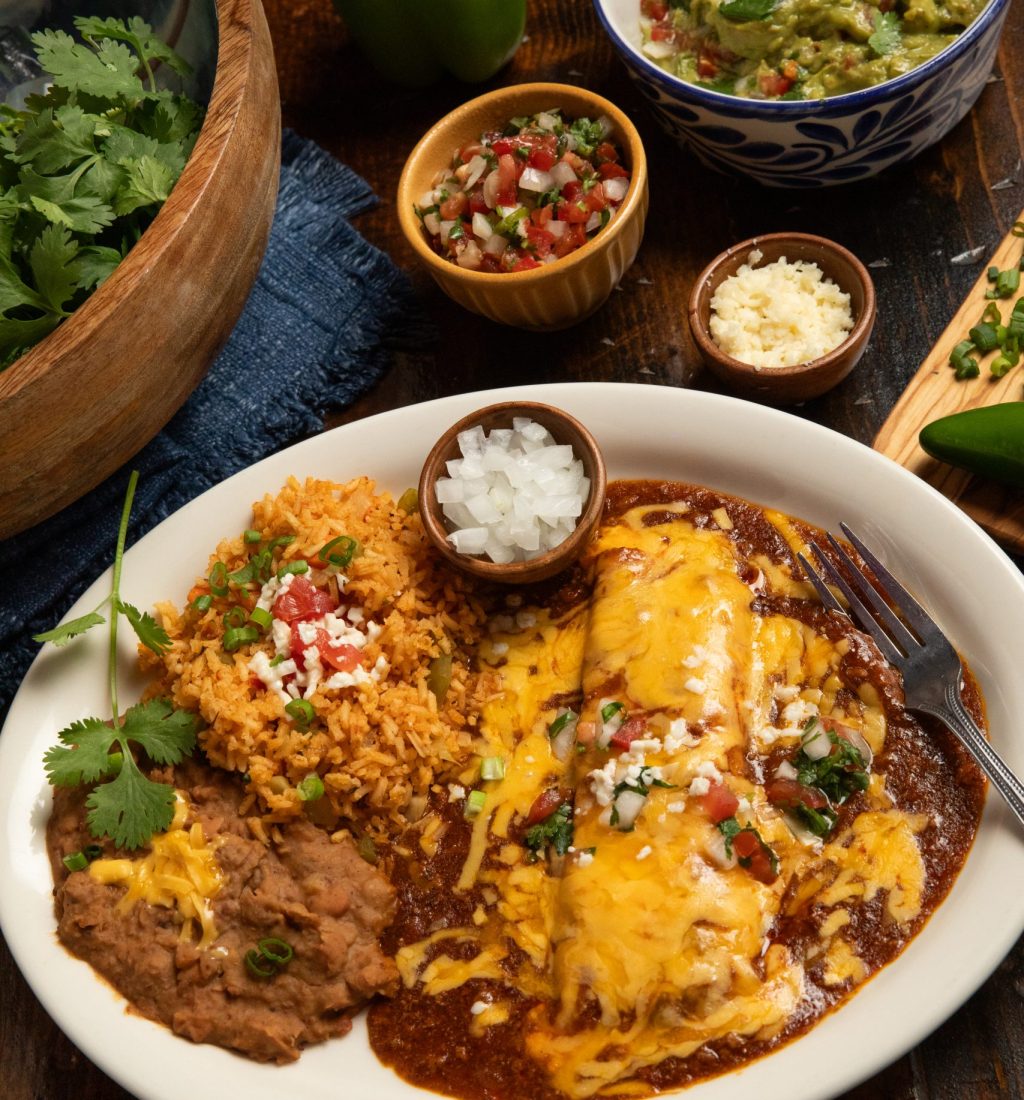 Enchiladas plate with spices, guacamole and cilantro