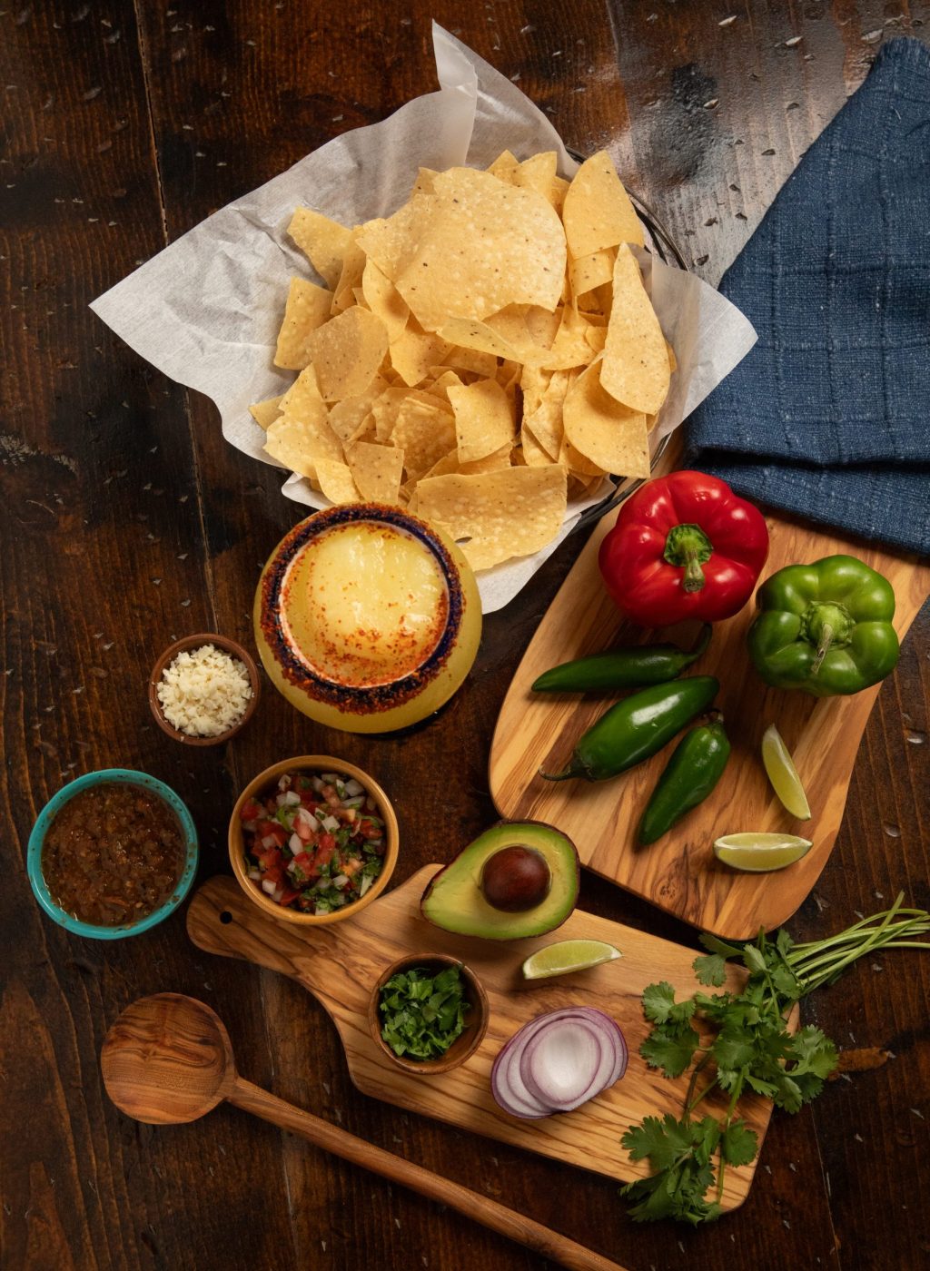 Table set with herbs, jalapeños, peppers, avocado and onions. chips and frozen margarita included