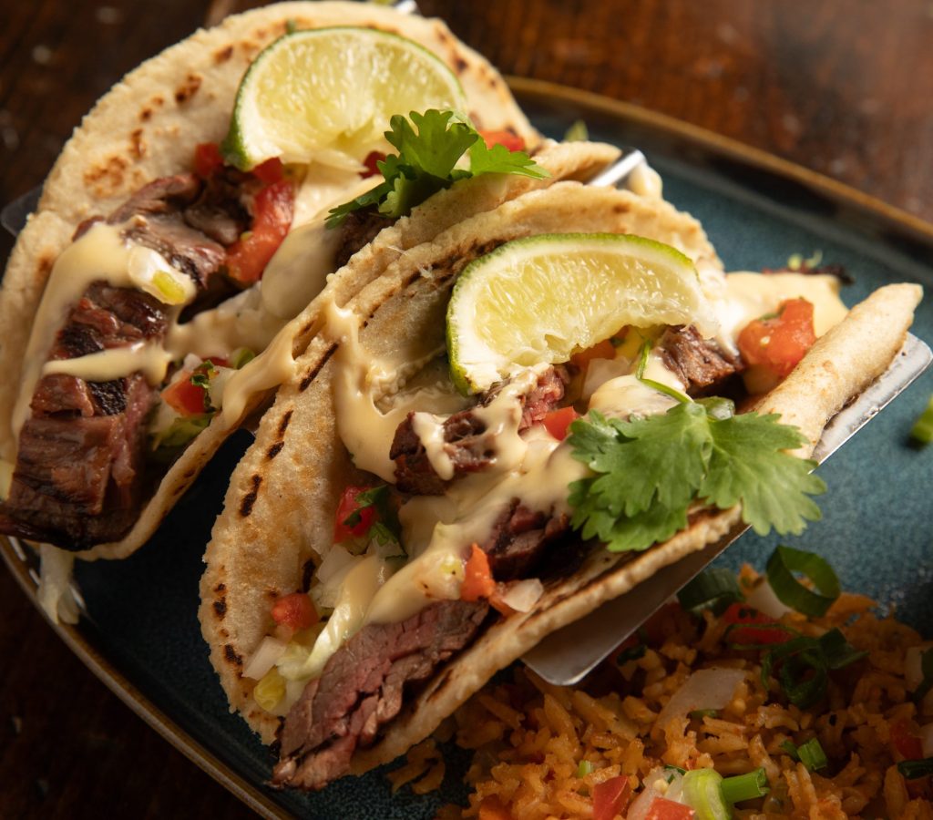 Close up of beef tacos on plate set on wooden table